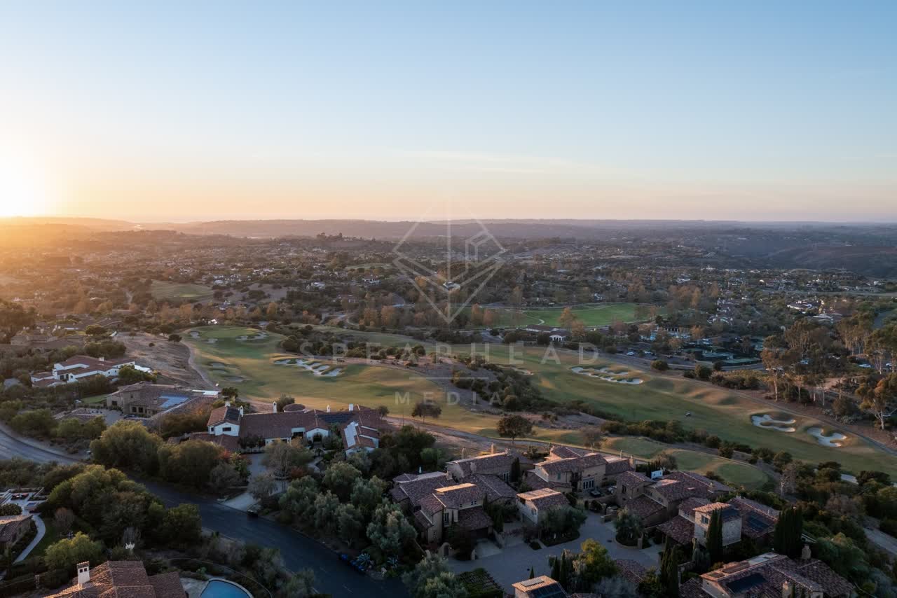Aerial view of a residential street, homes and open country in Santaluz.
