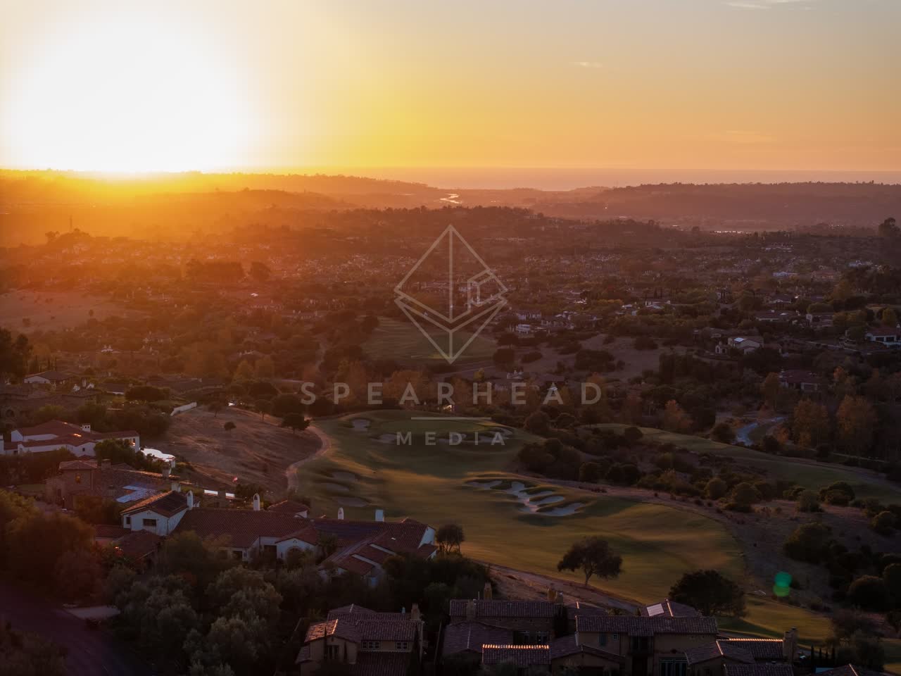 Aerial view of a residential street, homes and open country in Santaluz.