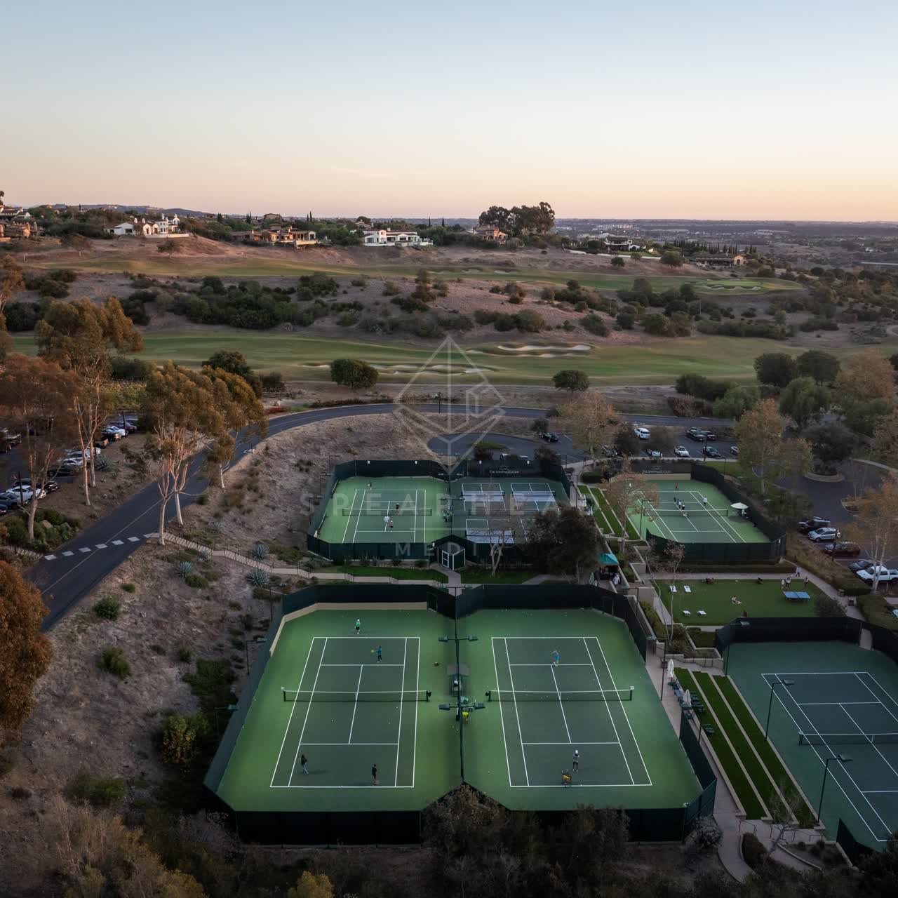 Aerial view of the country inland, homes and traffic in Santaluz, with a crowd gathered.