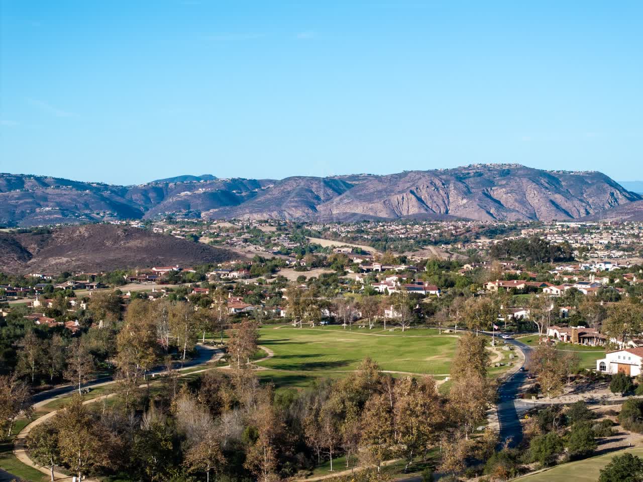 Aerial view of a residential street, homes and traffic in Santaluz.