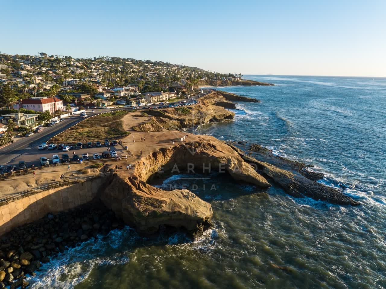 Aerial view of the cliffs, the ocean and homes at Sunset Cliffs, with people walking.