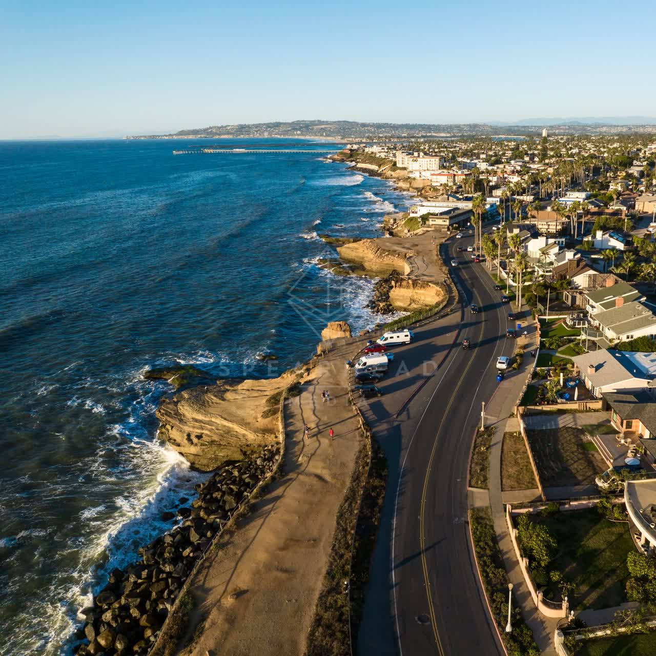 Aerial view of the cliffs, the pier and the ocean at Sunset Cliffs, with people walking.