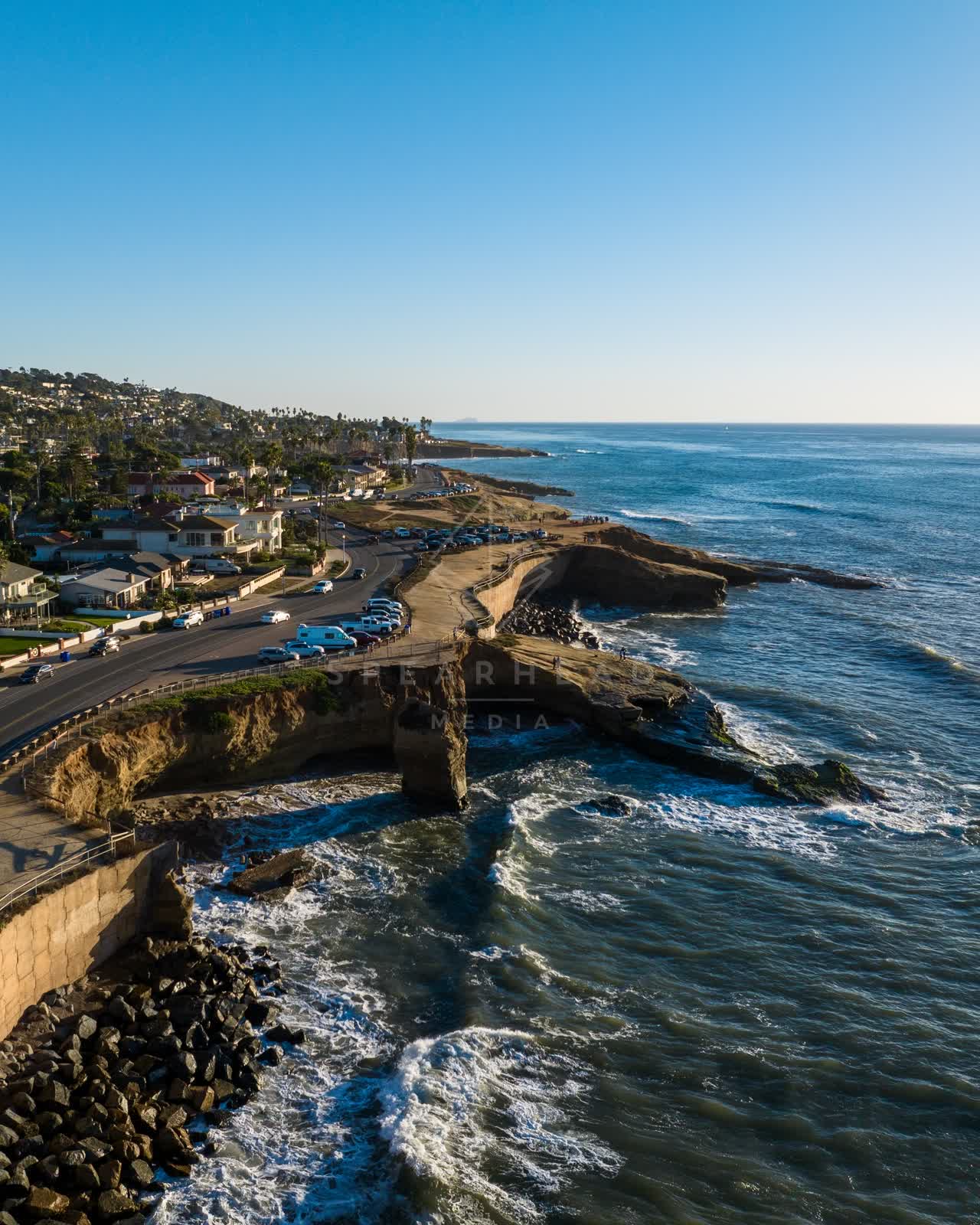 Aerial view of the cliffs, the surf and palm trees at Sunset Cliffs.
