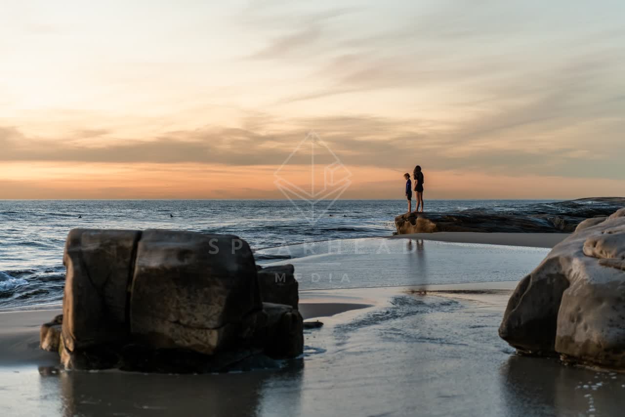 The beach, the surf and the ocean at Windansea, with people walking.