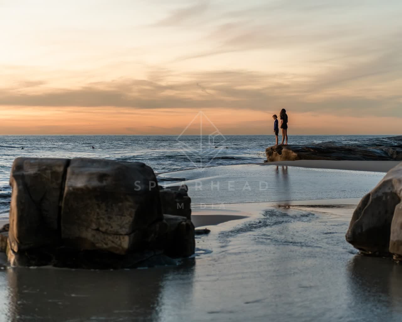 The beach, the surf and the ocean at Windansea, with people walking.