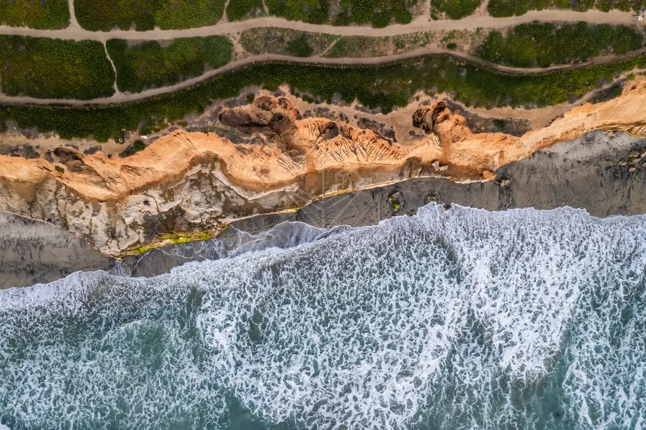 Aerial view of the cliffs, the surf and the ocean at Terramar Beach.