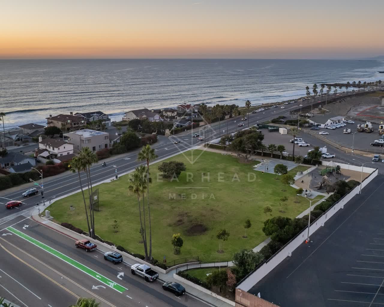 Aerial view of a residential street, palm trees and the ocean at Terramar Beach, with people walking.