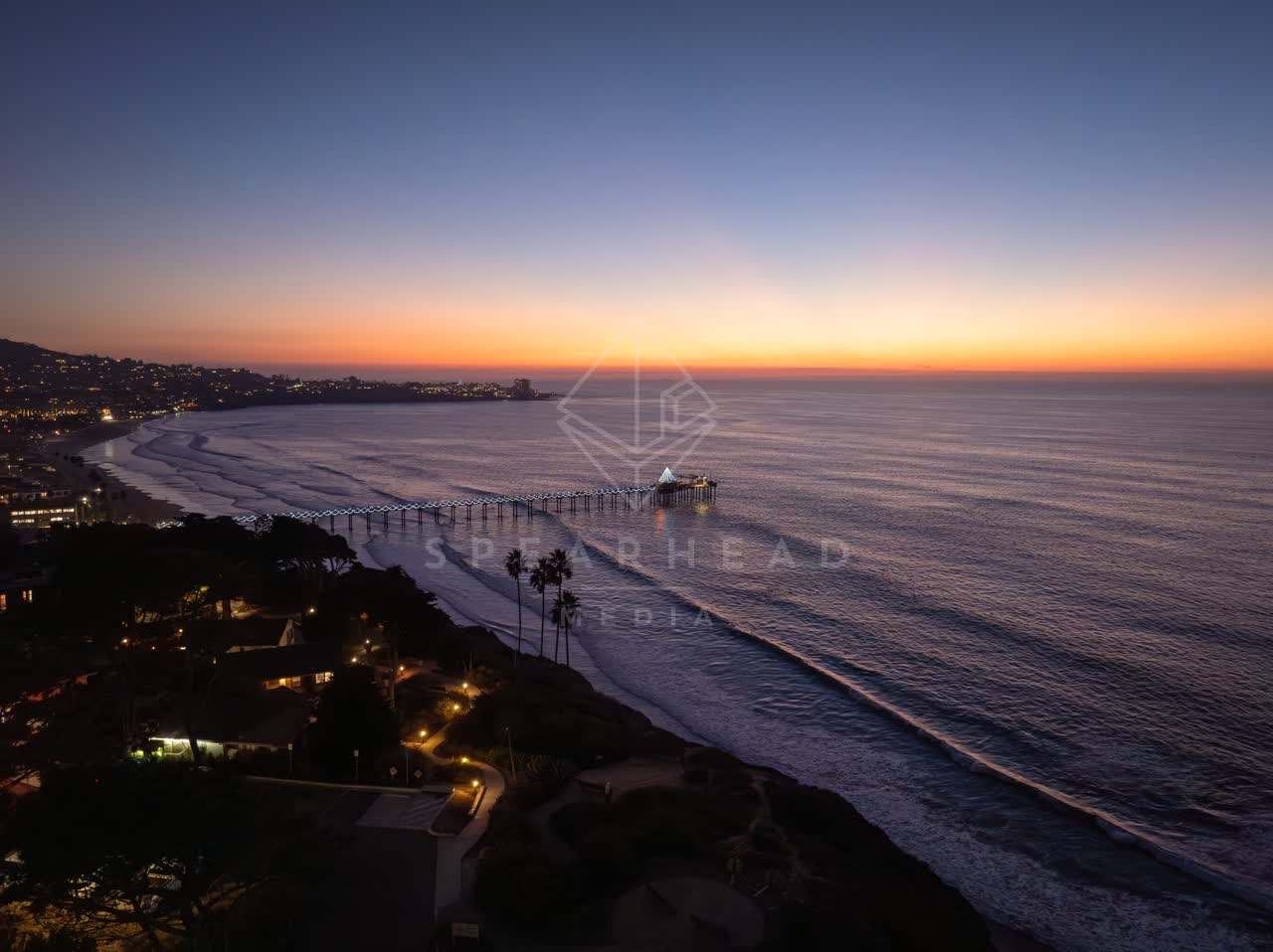Aerial view of the cliffs, the surf and the pier at La Jolla Shores.