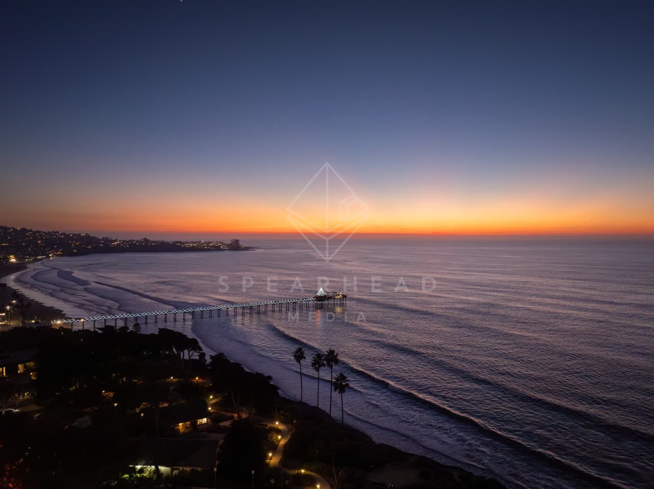 Aerial view of the beach, the pier and palm trees at La Jolla Shores.