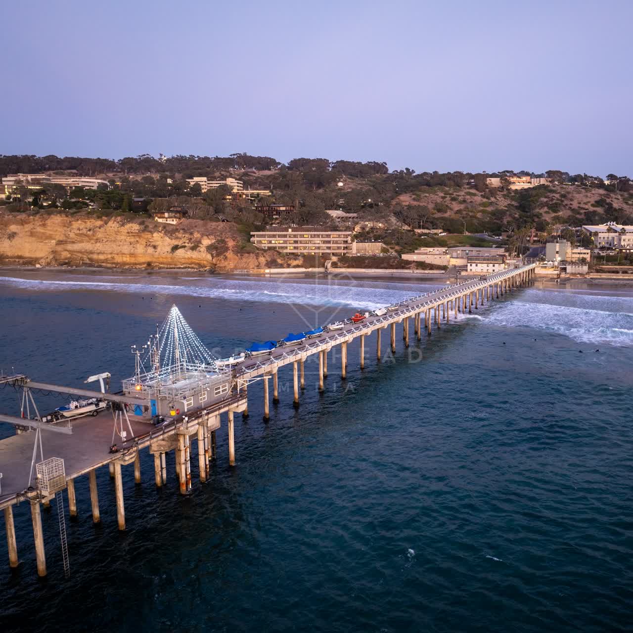 Aerial view of the beach, the surf and the pier at La Jolla Shores.