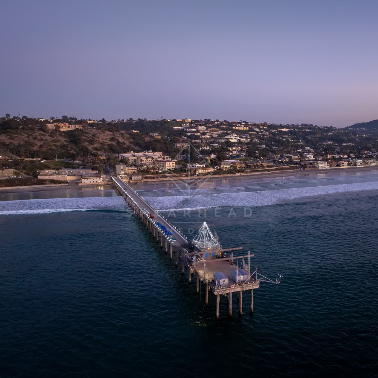 Aerial view of the beach, the surf and the pier at La Jolla Shores.