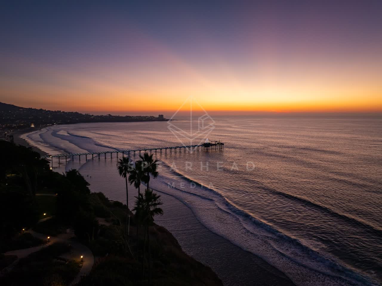 Aerial view of the cliffs, the surf and the pier at La Jolla Shores.