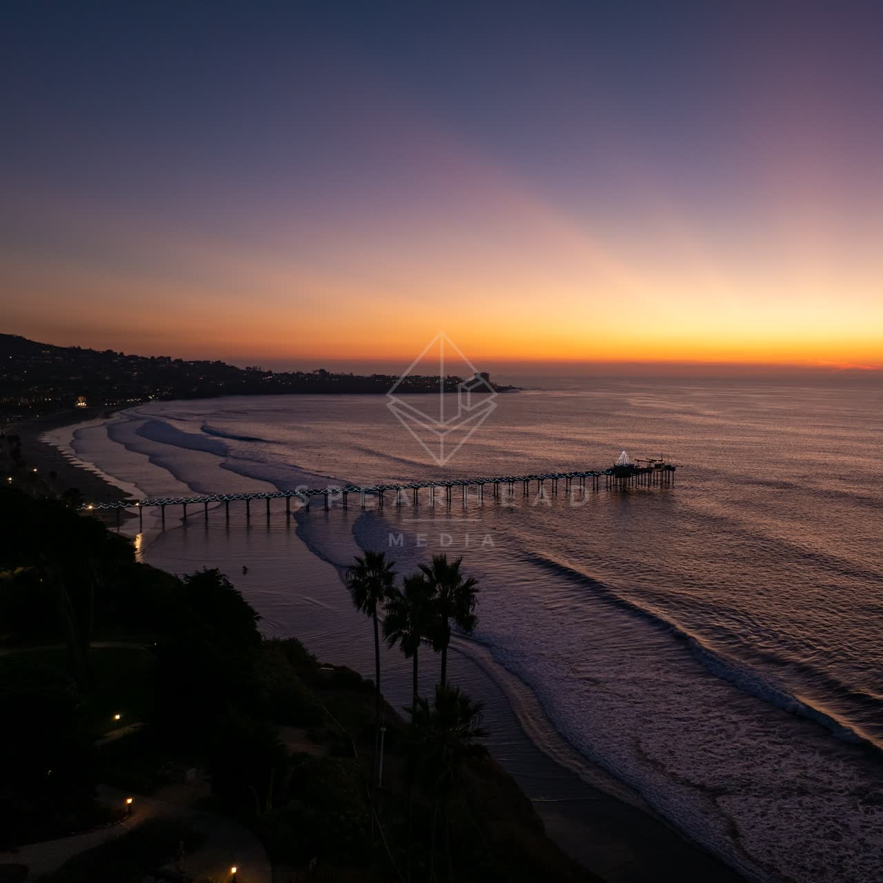 Aerial view of the beach, the surf and the pier at La Jolla Shores.