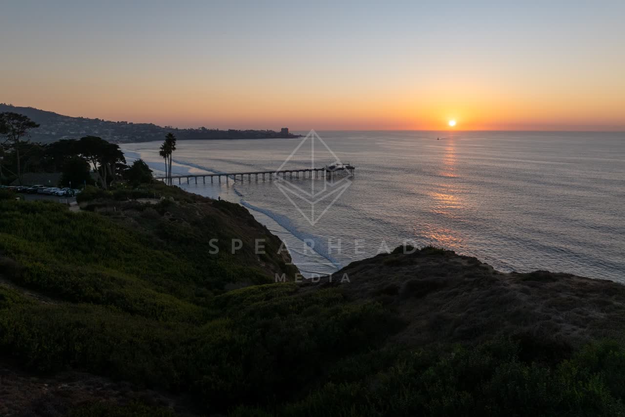 Elevated view of the cliffs, the pier and palm trees at La Jolla Shores.