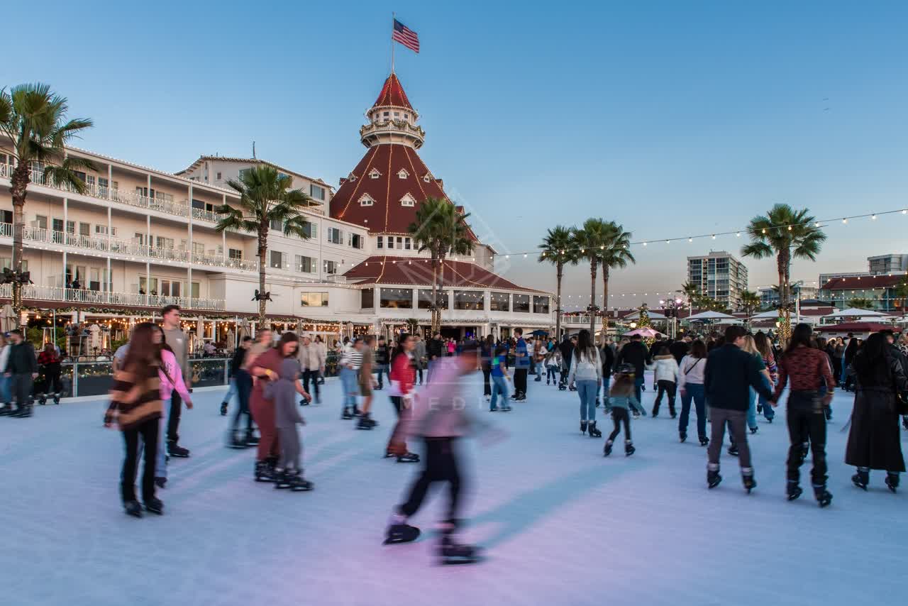 The downtown streets, palm trees and the buildings at Coronado Beach, with a crowd gathered.
