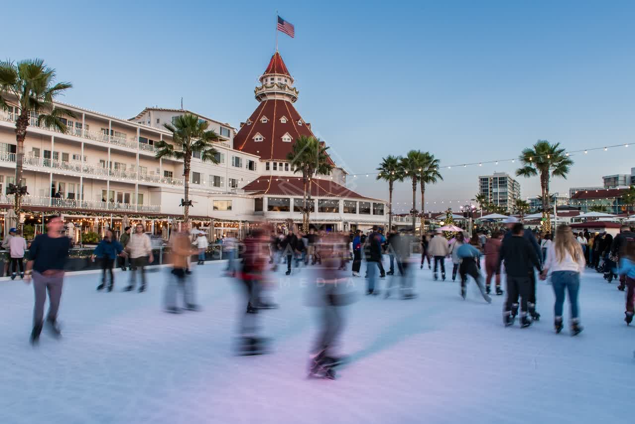 The downtown streets, palm trees and the buildings at Coronado Beach, with a crowd gathered.
