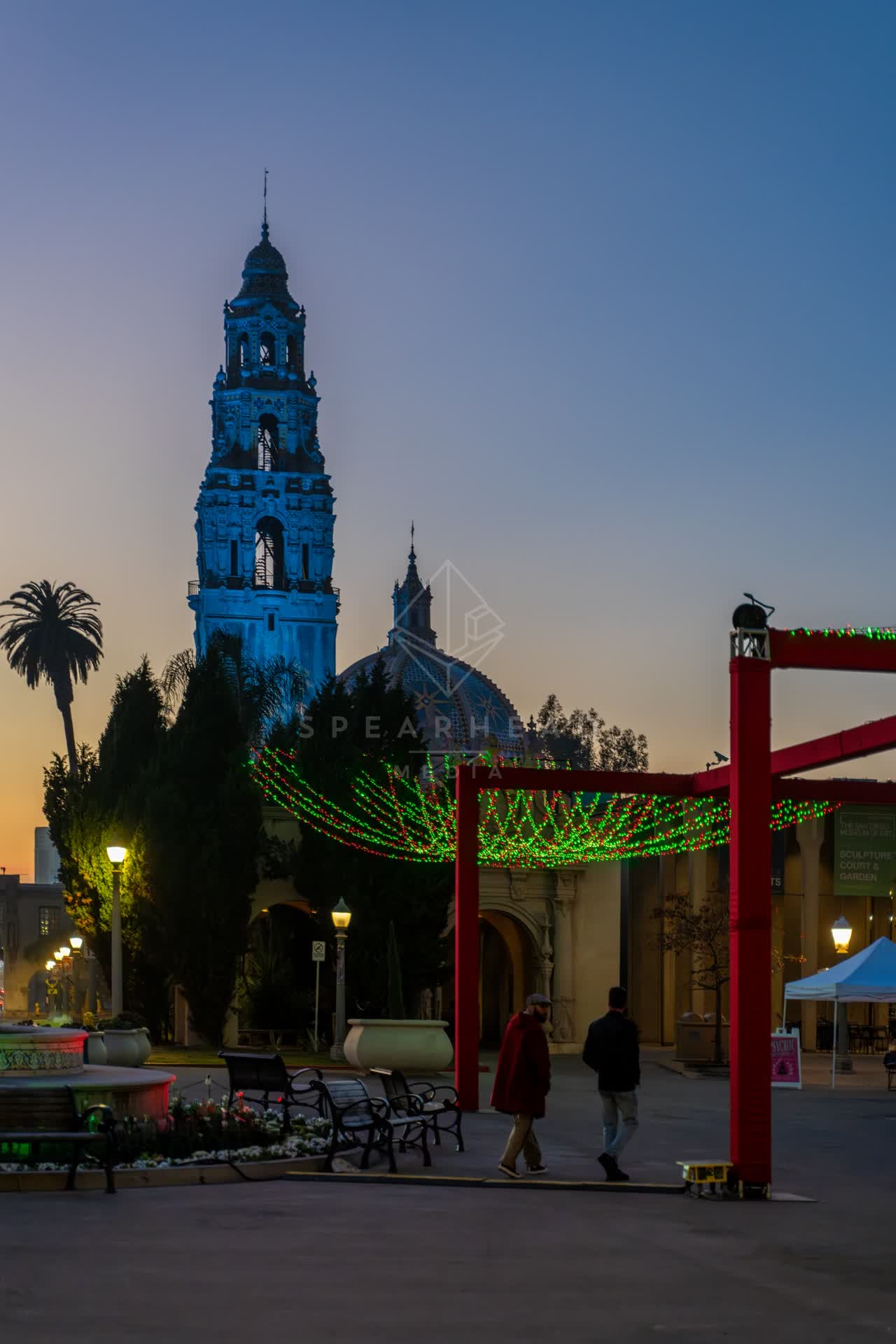 A park, palm trees and the buildings in Balboa Park, with people walking.