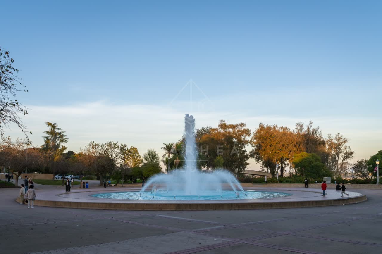 A park, palm trees and open country in Balboa Park, with people walking.