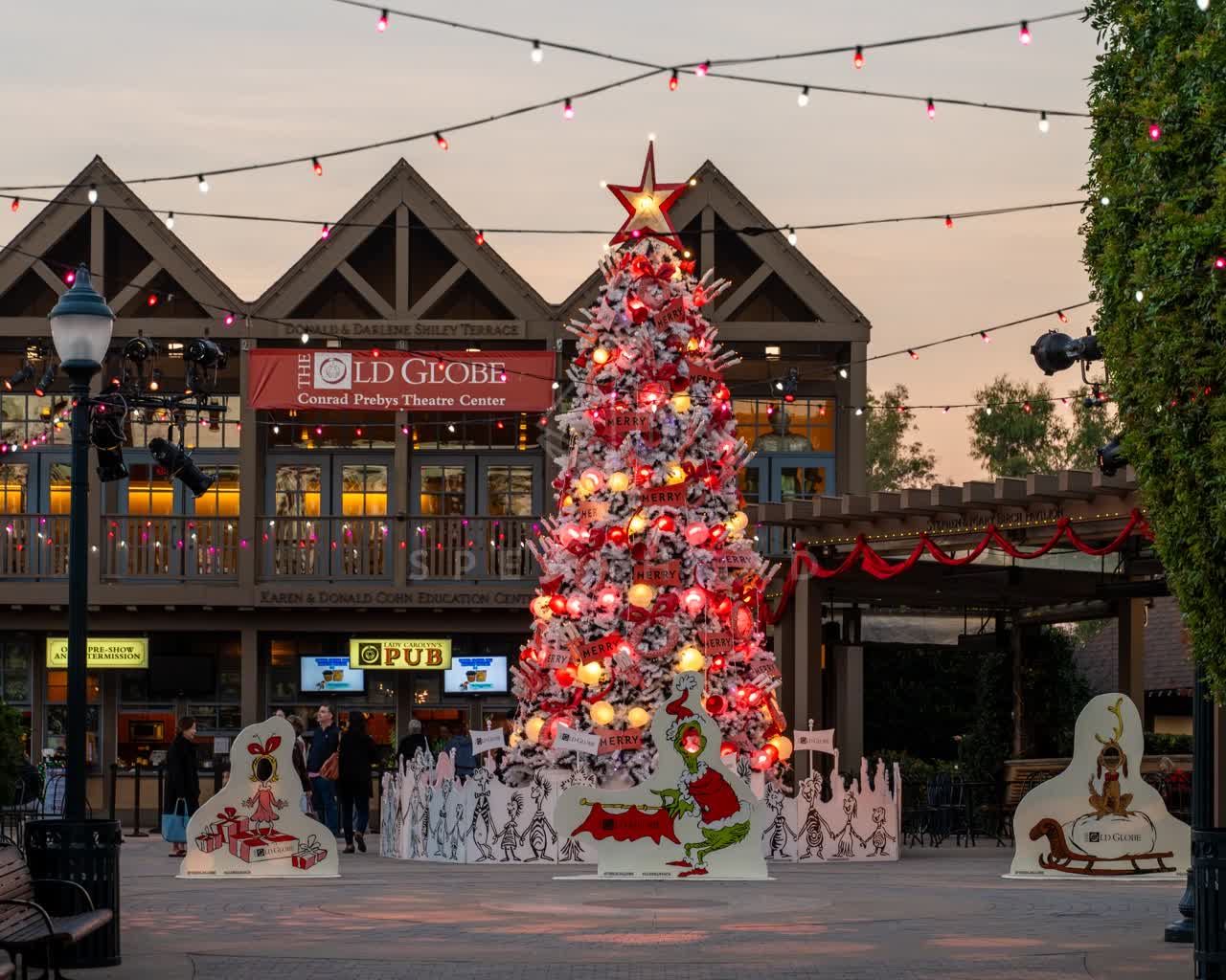 A park and the buildings in Balboa Park, with a crowd gathered.