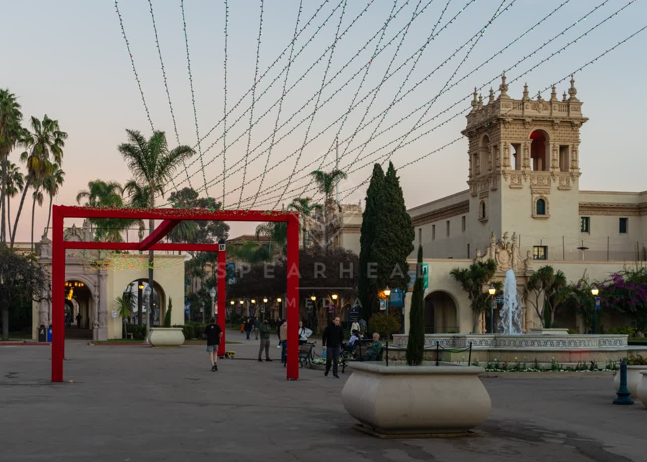 A park, palm trees and the buildings in Balboa Park, with people walking.
