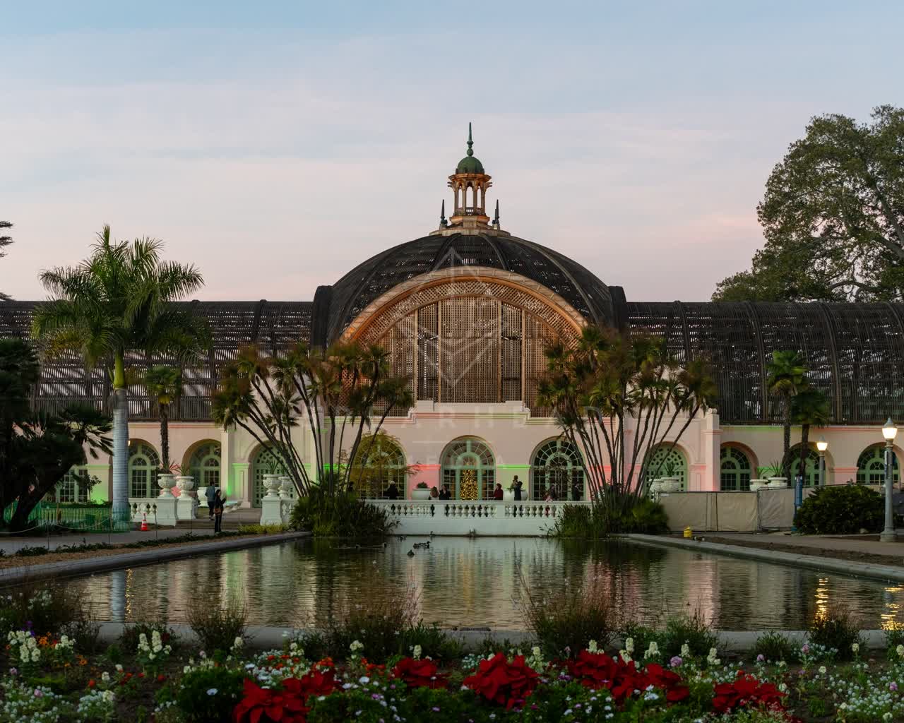 A park, palm trees and the buildings in Balboa Park, with people walking.