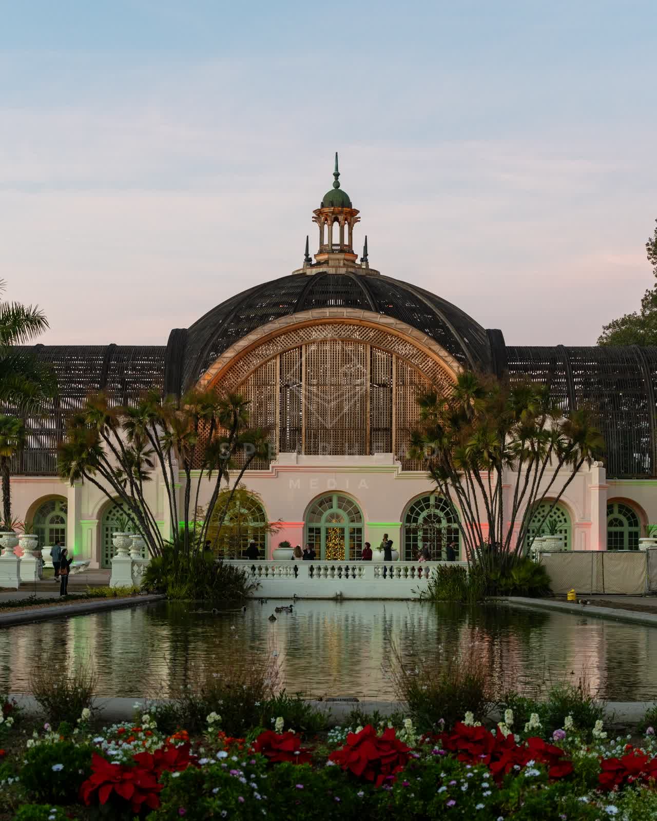 A park, palm trees and the buildings in Balboa Park, with people walking.