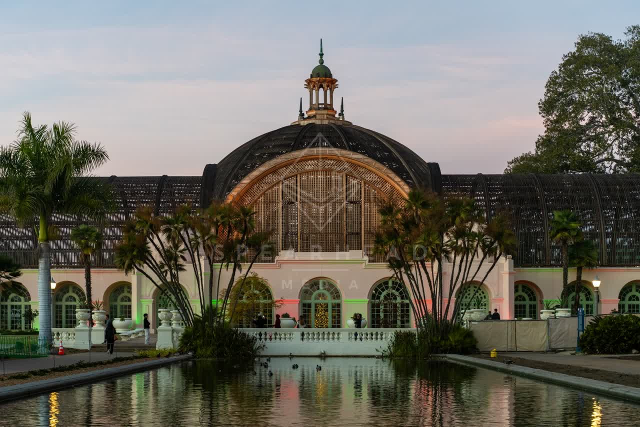 A park, palm trees and the buildings in Balboa Park, with people walking.