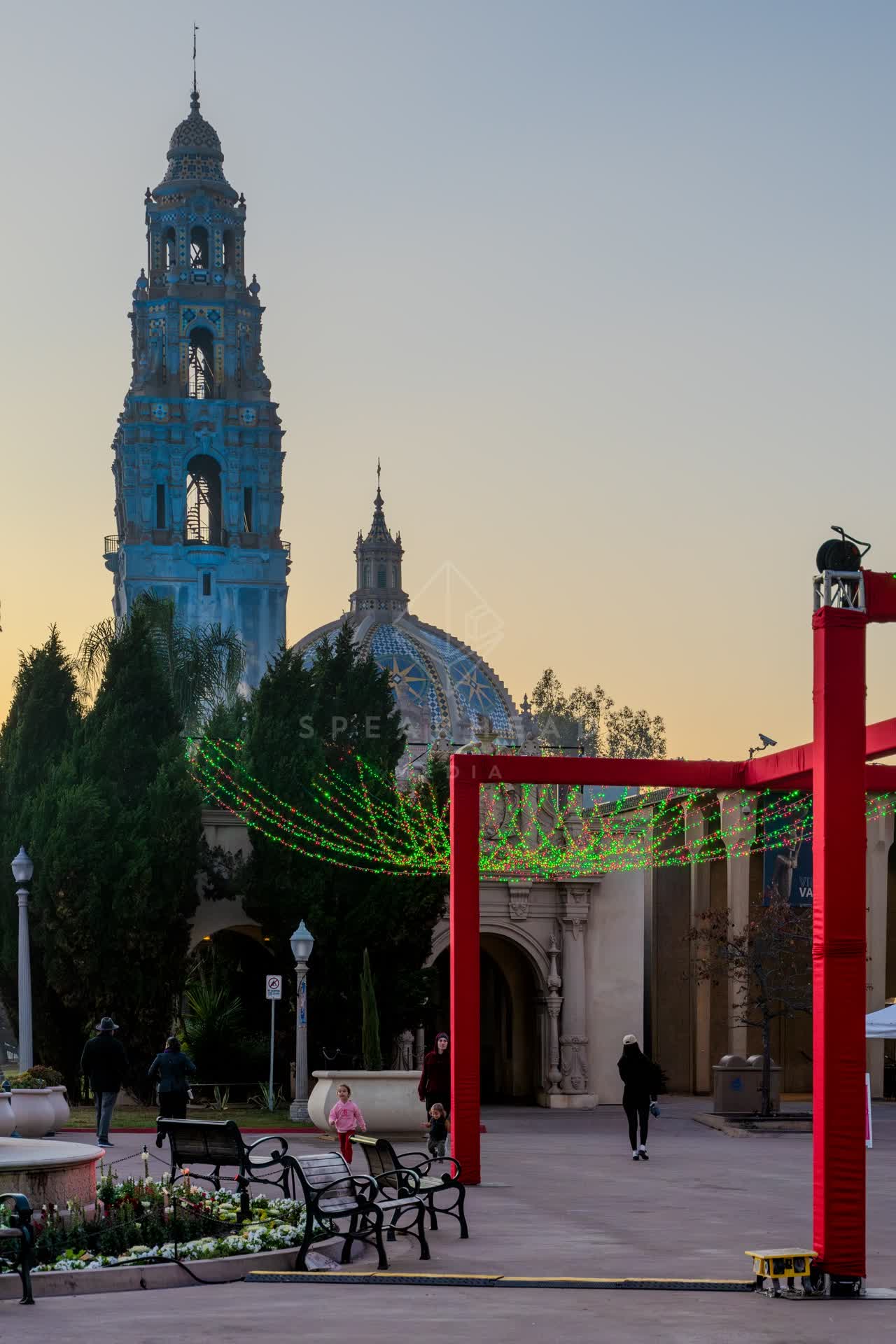 A park, palm trees and the buildings in Balboa Park, with people walking.