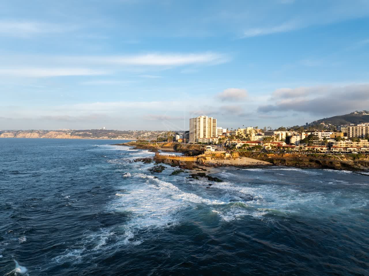 Aerial view of the cliffs, the surf and the ocean at La Jolla Cove.