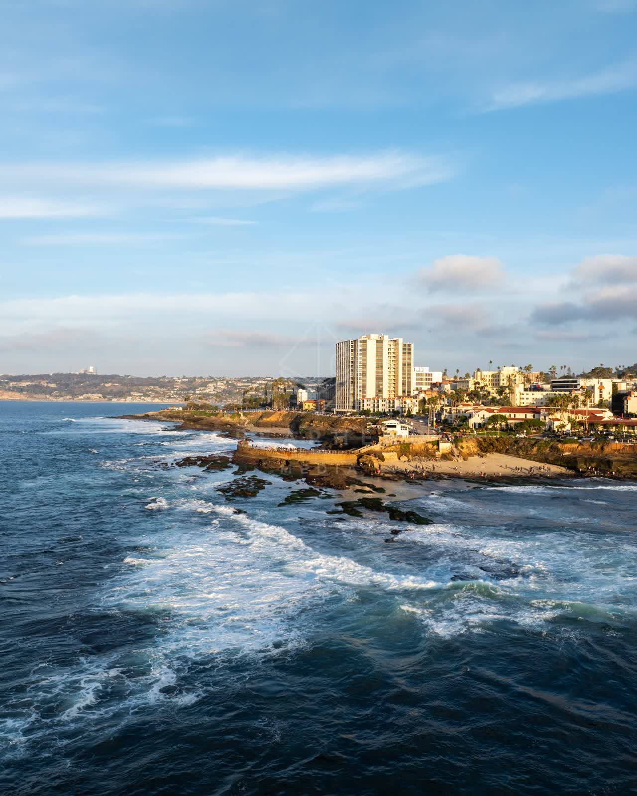 Aerial view of the cliffs, the surf and the ocean at La Jolla Cove.