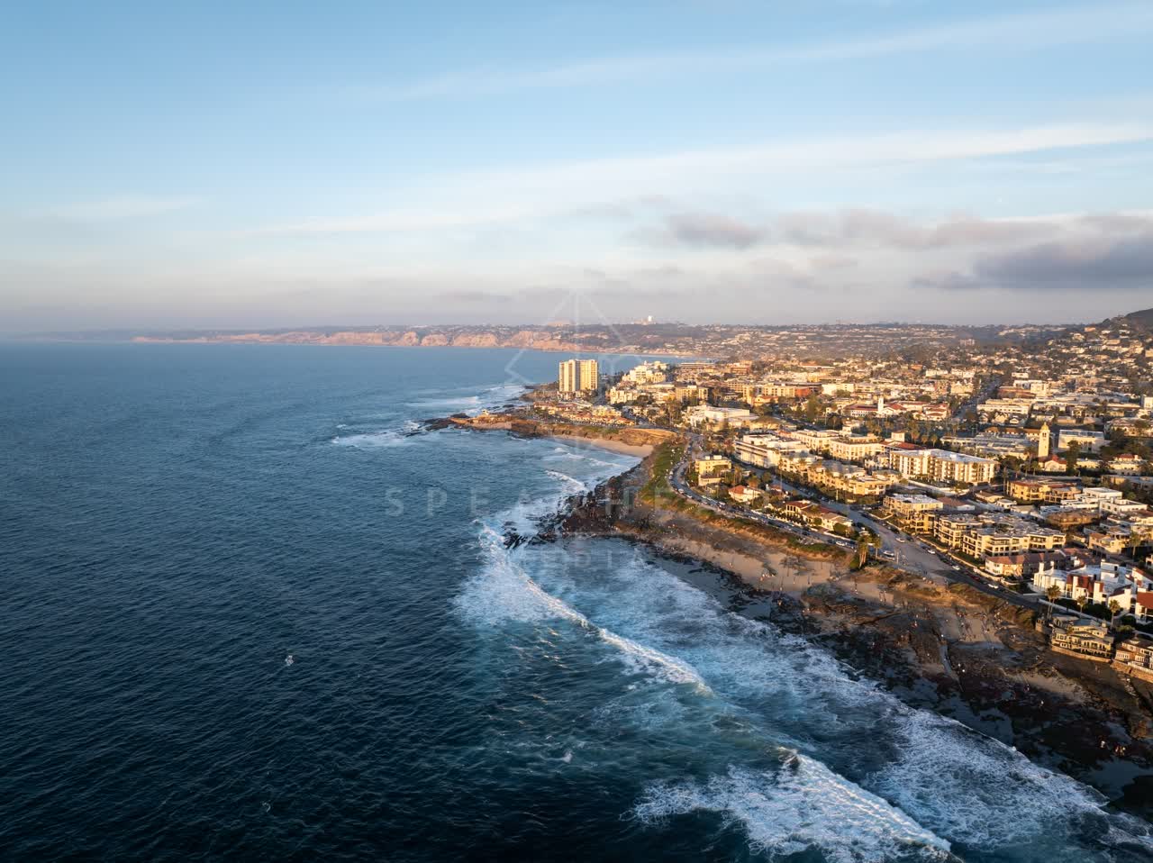 Aerial view of the cliffs, the surf and the ocean at La Jolla Cove.