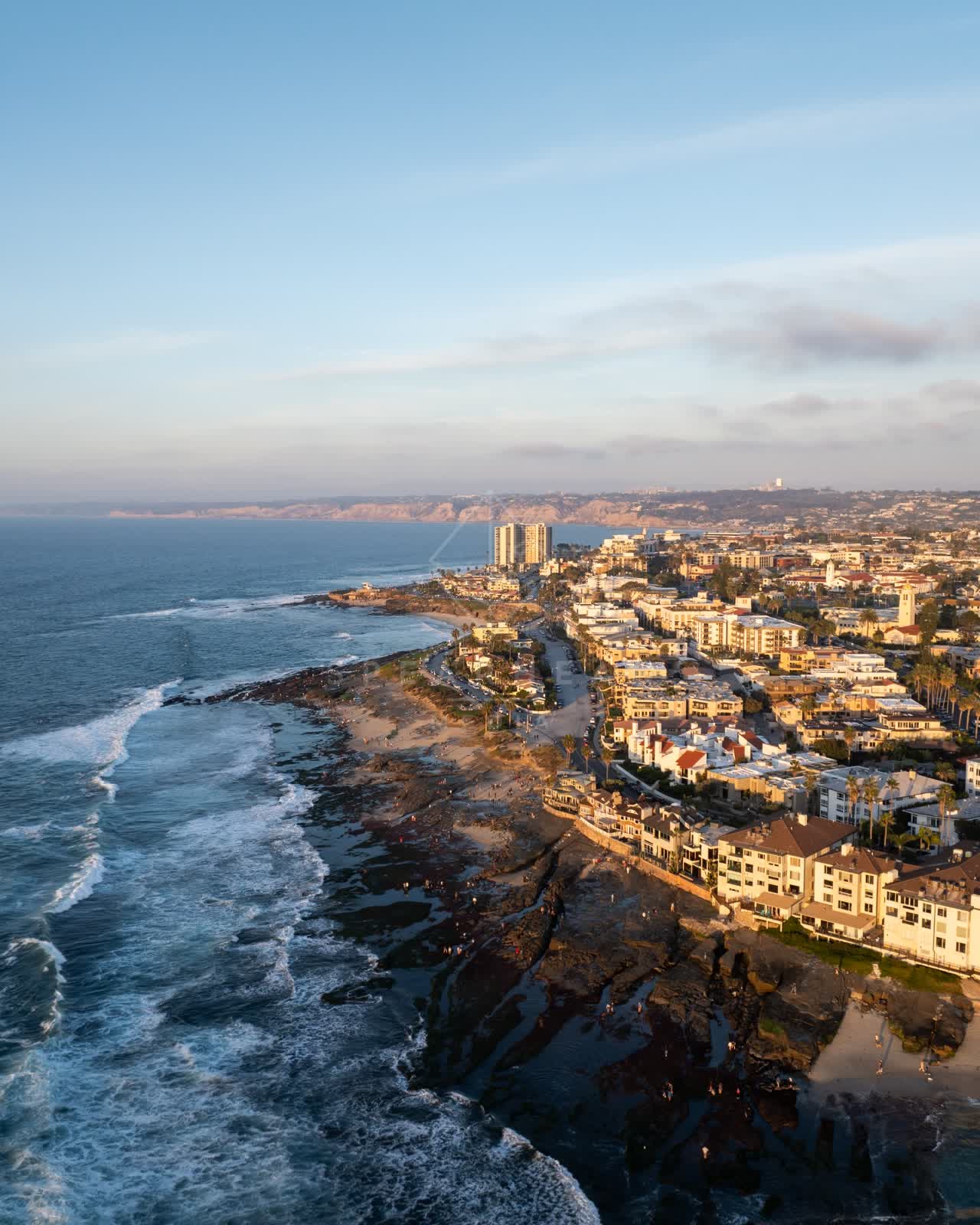 Aerial view of the beach, the surf and palm trees at La Jolla Cove.