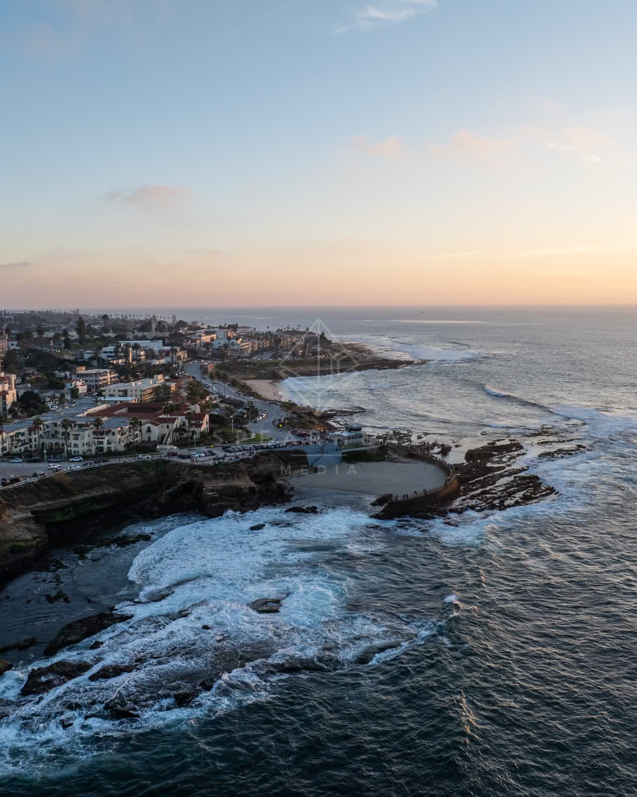 Aerial view of the cliffs, the surf and the ocean at La Jolla Cove.
