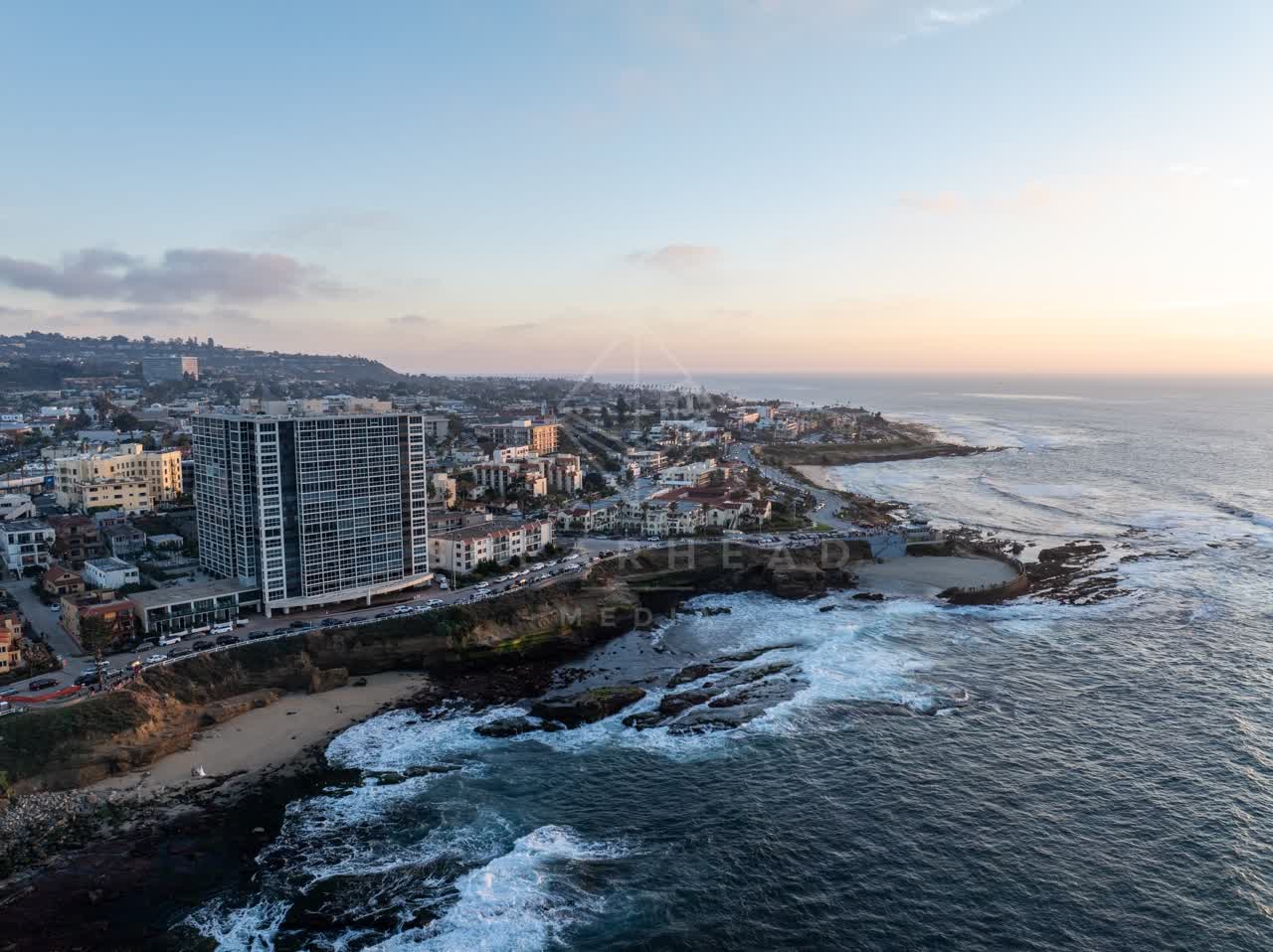 Aerial view of the cliffs, the surf and the ocean at La Jolla Cove.
