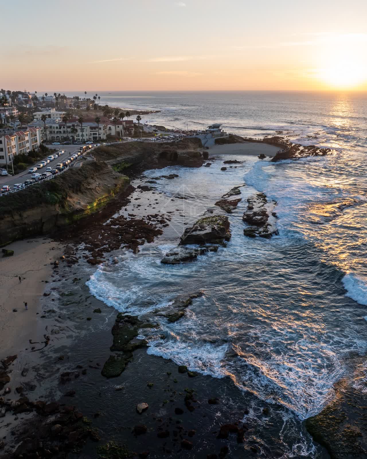 Aerial view of the cliffs, the surf and boats at La Jolla Cove.