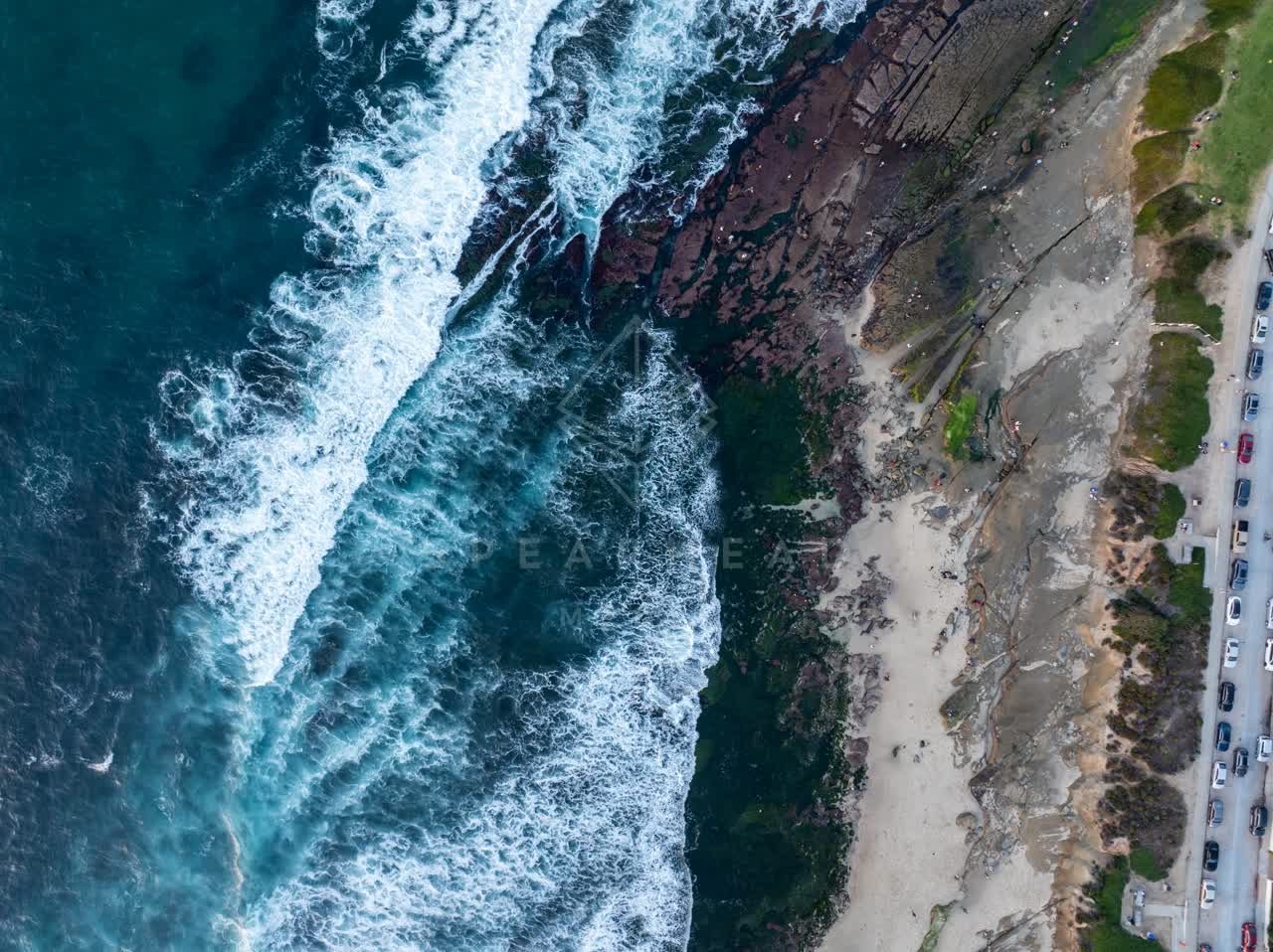 Aerial view of the cliffs, the surf and the ocean at La Jolla Cove.