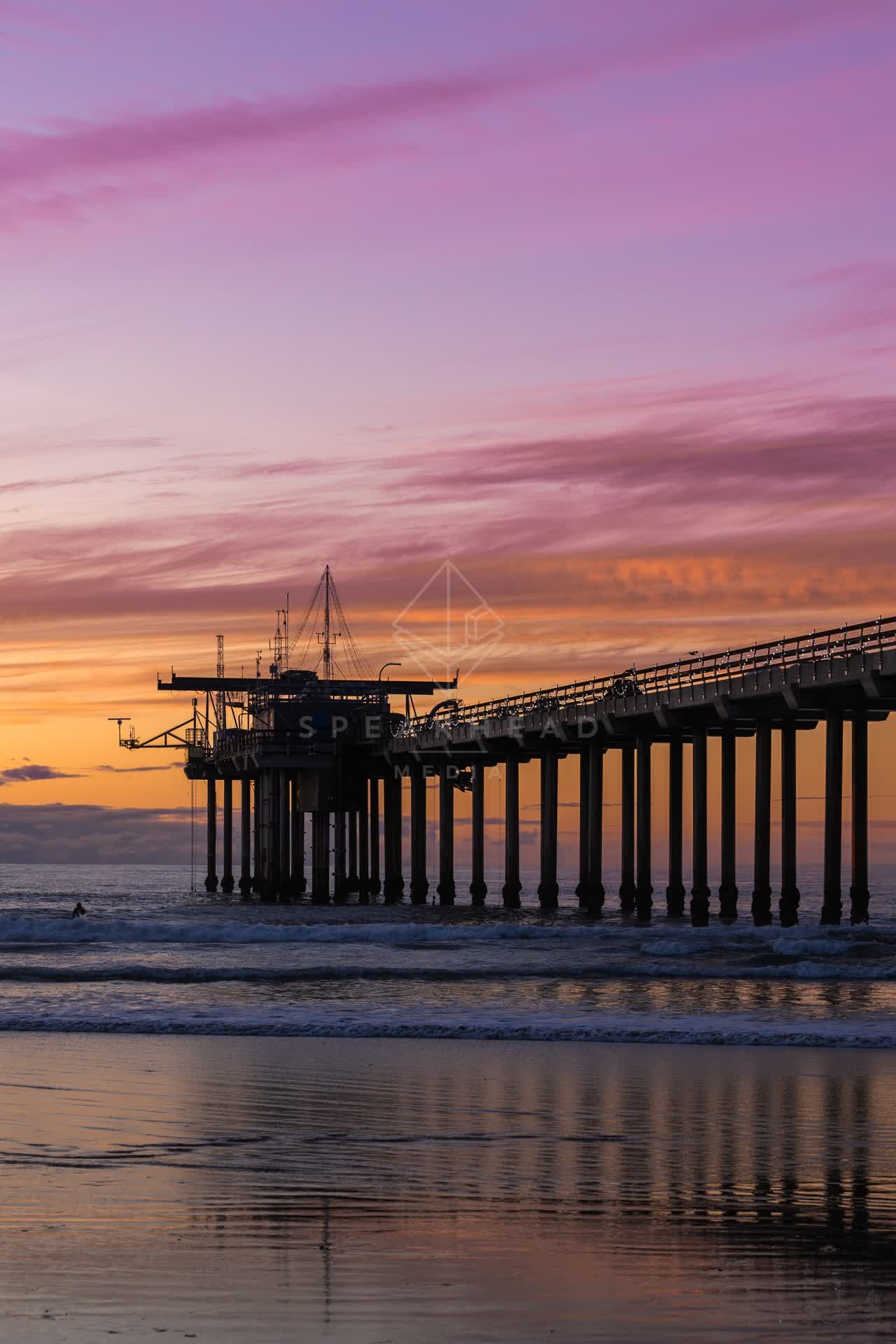 The beach, the surf and the pier at La Jolla Shores, with surfers out.