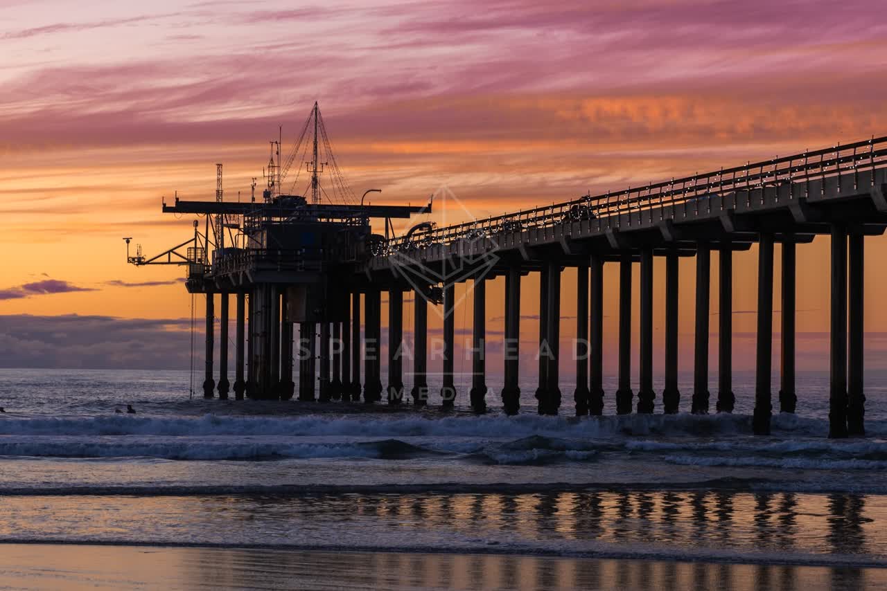 The beach, the surf and the pier at La Jolla Shores, with surfers out.