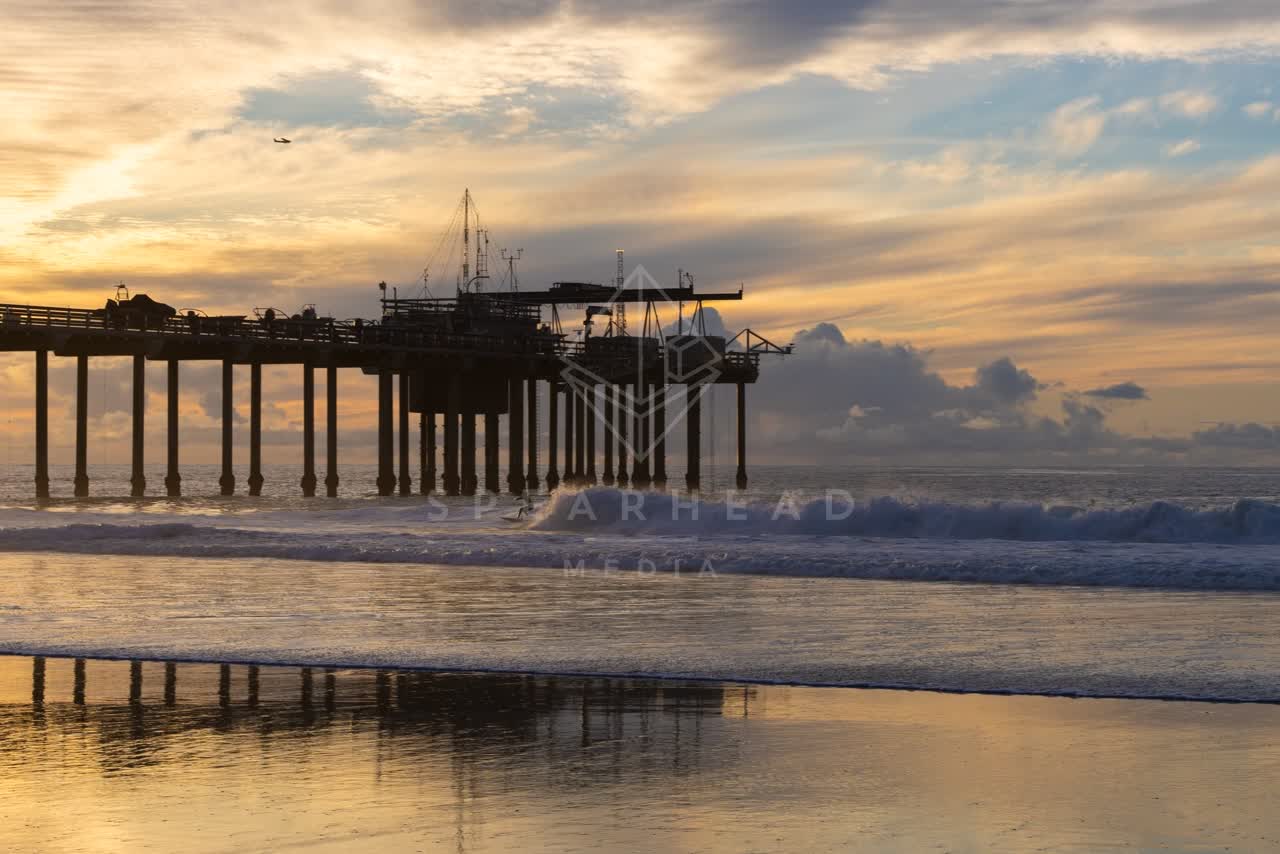 The beach, the surf and the pier at La Jolla Shores, with surfers out.