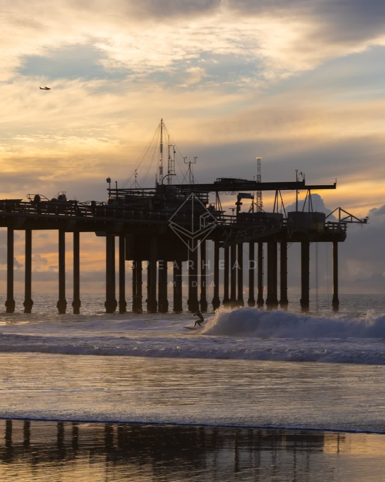 The beach, the surf and the pier at La Jolla Shores, with surfers out.