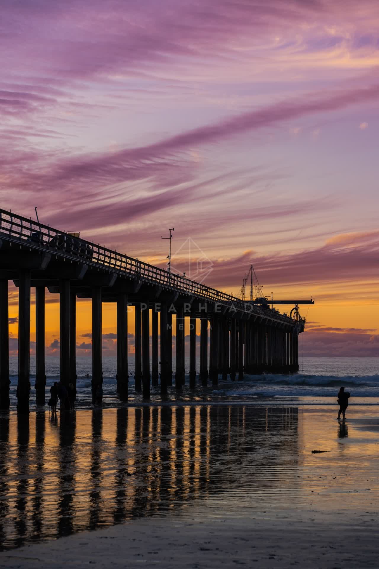 The beach, the pier and the ocean at La Jolla Shores, with people walking.