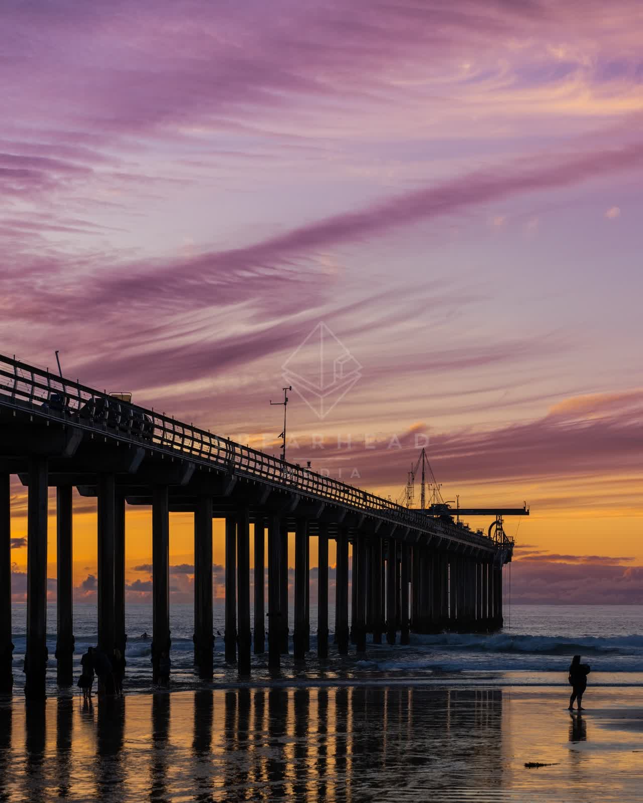 The beach, the surf and the pier at La Jolla Shores, with people walking.