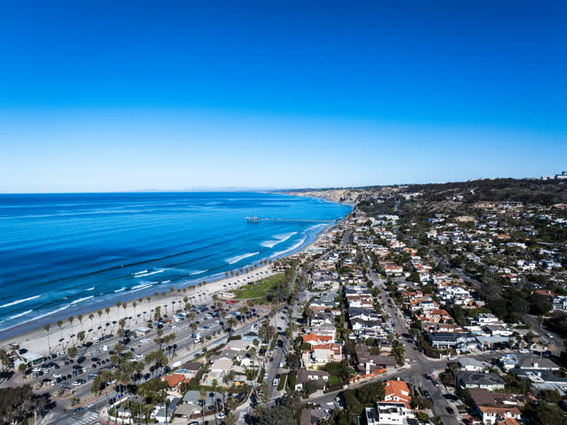 Aerial view of a residential street, the pier and palm trees at La Jolla Shores.