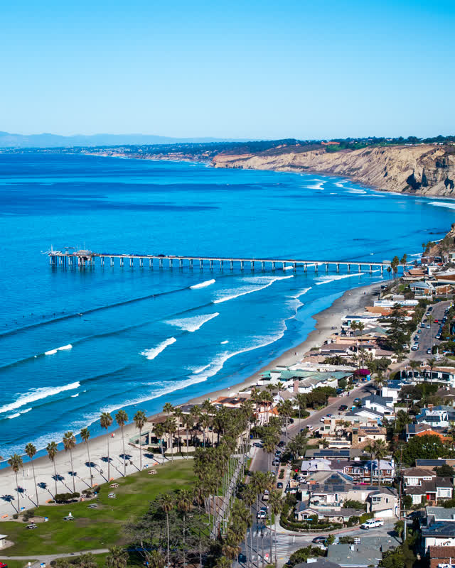 Aerial view of the beach, the surf and the pier at La Jolla Shores.