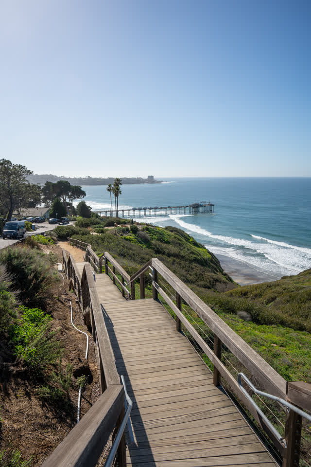 Elevated view of the cliffs, the surf and the pier at La Jolla Shores.