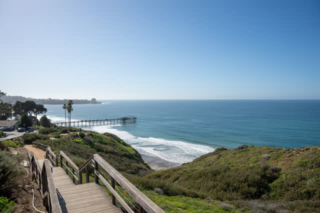 Elevated view of the cliffs, the surf and the pier at La Jolla Shores.
