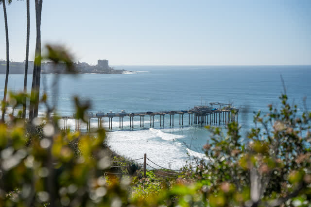 Elevated view of the cliffs, the surf and the pier at La Jolla Shores.