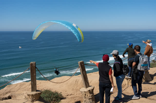 Elevated view of the cliffs, the ocean and open country at Torrey Pines, with a crowd gathered.