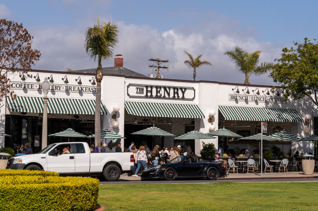 The downtown streets, palm trees and the buildings in Coronado, with people eating outside.