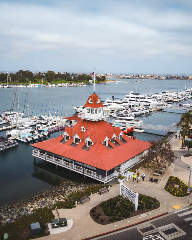 Aerial view of the harbor, boats and the bay at Coronado Beach, with people walking.